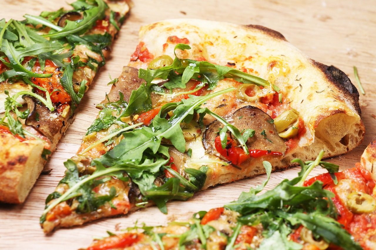 Pizza z grilla z sosem pomidorowym, plasterkami salami i świeżą rukolą na chrupiącym cieście.